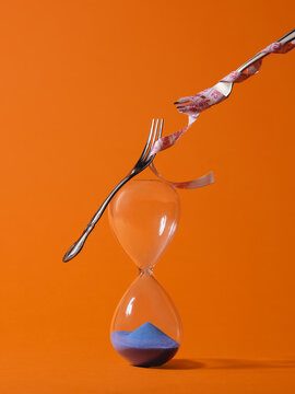 Balancing act of forks and measuring tape on hourglass symbolizes