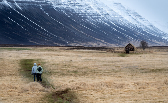 Hikers Walking Toward a Traditional Grafarkirkja turf church Iceland. Icelandic famous turf church