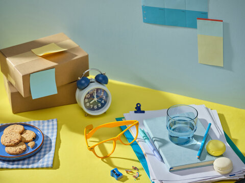 Desk with study supplies, snacks, and packages, bright morning light