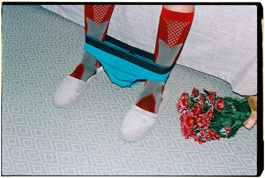 a bouquet lies beside a man with underwear at his ankles, 35mm film