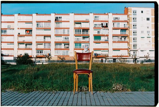 a weathered chair stands by an overgrown field, 35mm film