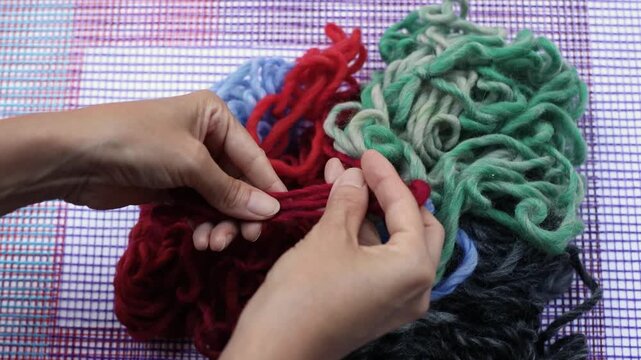 Hands untangling colorful yarn skeins for textile craft project