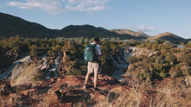Adventurous man trekking and admiring Epupa Falls in Namibia