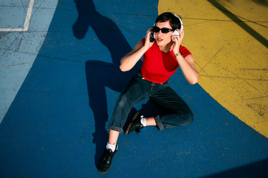 Woman listening music, enjoying urban colorful pavement