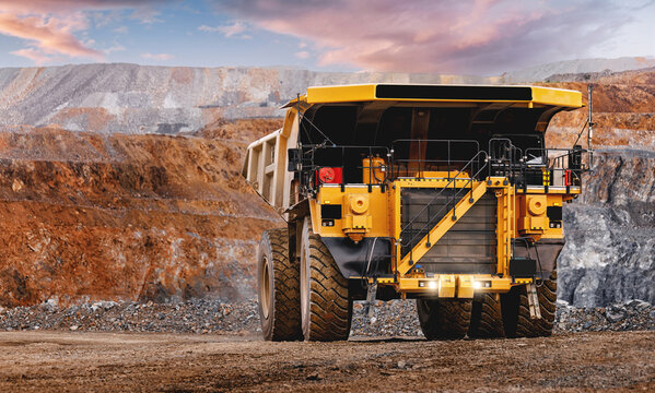 Massive yellow mining dump truck in open pit mine landscape in open pit mine with gold ore