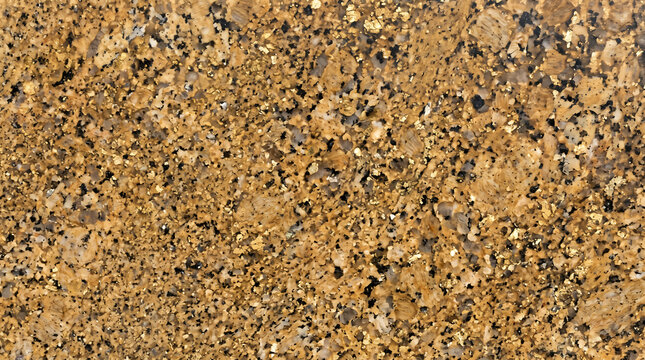 Golden brown granite stone surface with dark mineral speckles natural rock texture background