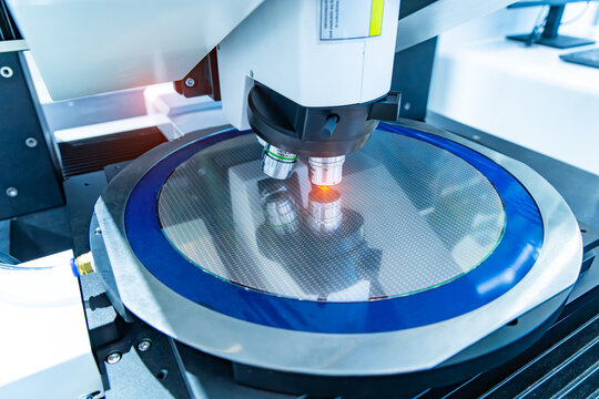 Silicon wafer with semiconductor microchip on machine process examining testing in microscope for manufacturing semiconductor of integrated circuit.