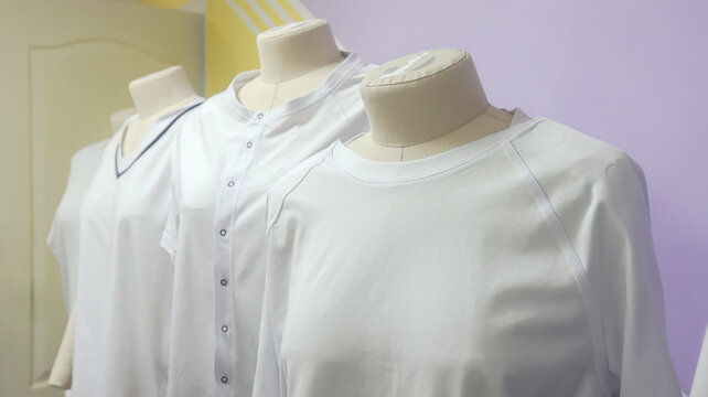 White custom t-shirts on professional tailor mannequins in a studio