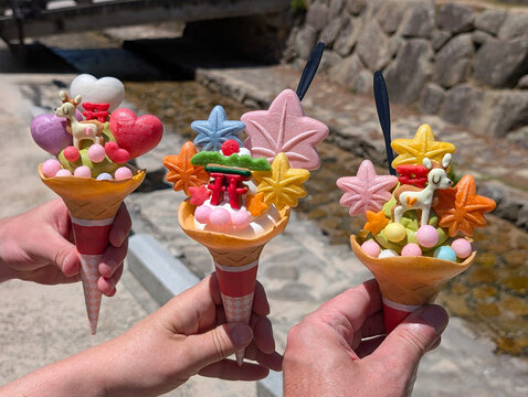 three matcha ice cream cones with colorful toppings on a sunny day