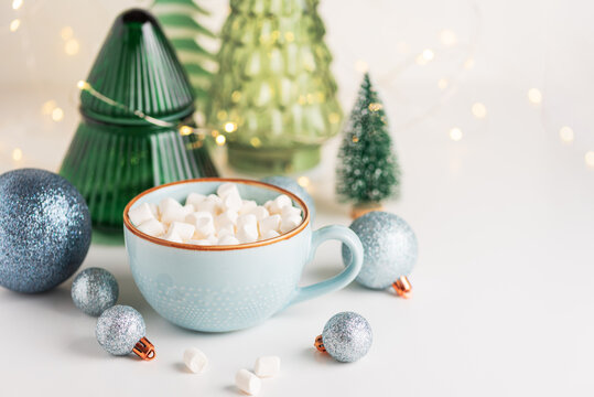Hot chocolate with marshmallows, Christmas ornaments, and festive decorations