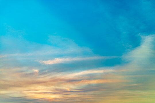 Beautiful vibrant blue sky with wispy cirrus clouds at sunset golden hour