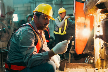 Industrial worker, hard hat, factory, safety gear, inspection, furnace, machinery worker using handheld device near hot furnace during equipment check © chokniti