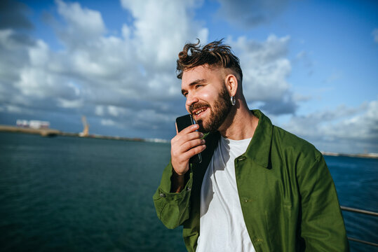 Young man sending a voice message with a smartphone.