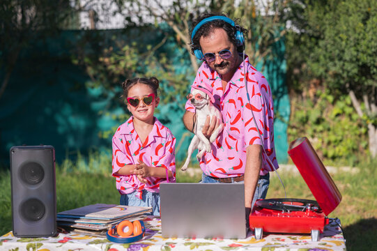Father and daughter djs playing music at a summer garden party