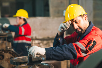 Construction worker hard hat safety glove industrial site factory uniform machine gear maintenance laborer sweating and working with equipment in workshop scene © chokniti