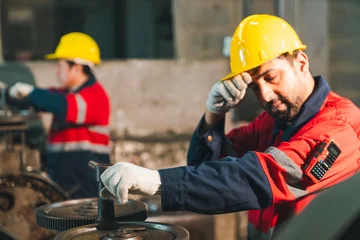 Construction worker hard hat safety glove industrial site factory uniform machine gear maintenance laborer sweating and working with equipment in workshop scene © chokniti