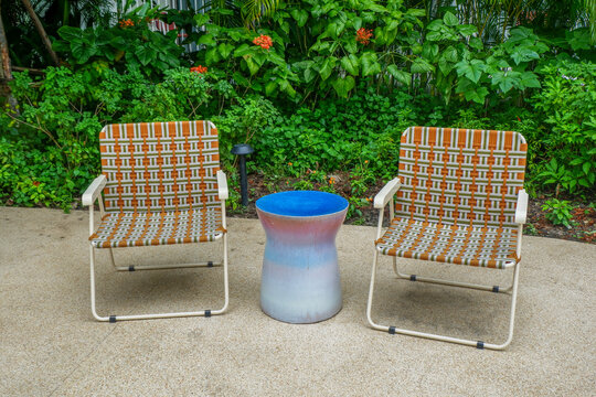 Wooden table and bench chair set in garden on a sunny day,outdoor seating for restaurant or cafe,Neat paved patio with sitting area and small garden in forest.