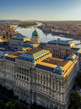 A unique aerial view of Buda Castle at sunrise, overlooking the Hungarian Parliament, the Danube, Margaret Island and Margaret Bridge.