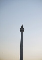 Obraz premium The National Monument (Monas) standing majestic against a clear afternoon sky background in Jakarta.