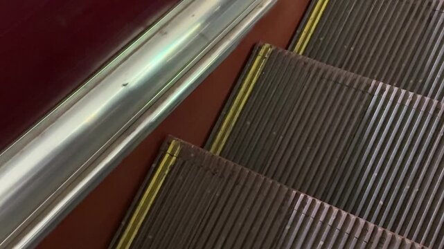 Escalator steps motion moving stairway mechanism in urban public transportation facility capturing industrial design and mechanical transit background for modern architecture