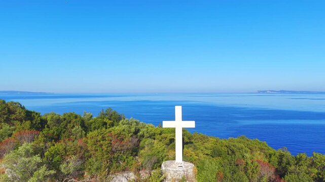 Aerial View of White Cross on Coastal Hill Above Arillas Bay, Epirus, Greece