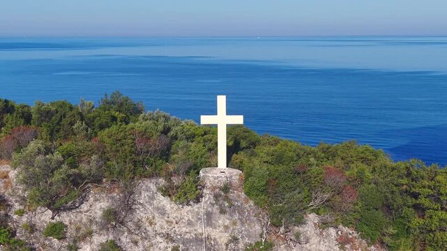 Aerial View of White Cross on Coastal Hill Above Arillas Bay, Epirus, Greece