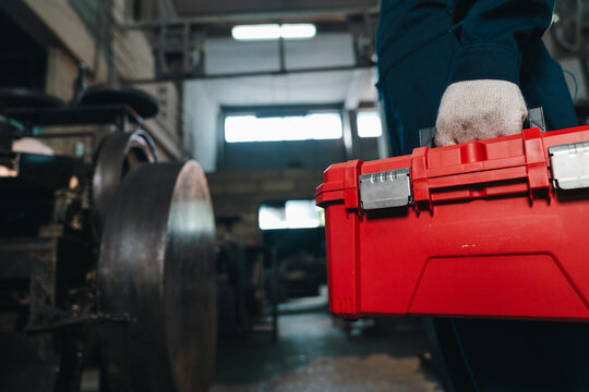 Toolbox worker glove workshop repair maintenance red equipment mechanic industrial worker hand carrying red toolbox workshop for machine repair maintenance, safety, trade, engineering