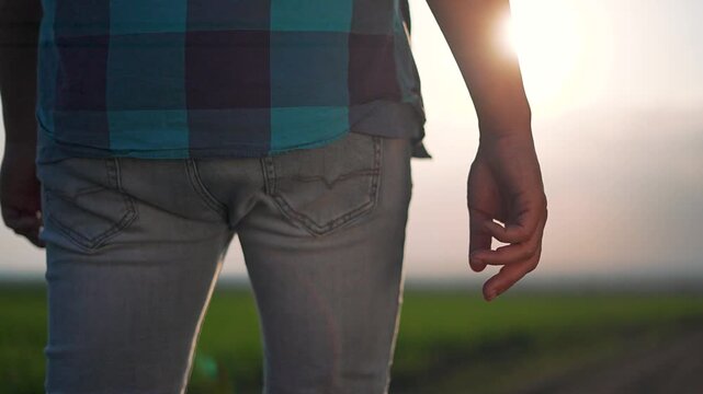 Man in field shows pattern of plaid shirt over fitted jeans. Field horizon blends into distance. Shirt lifts movement. Jeans stay firm. Field expands under shirt motion. Plaid shirt marks outdoor calm