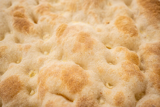 Pizza crust texture close-up of freshly baked dough, crispy golden brown surface of traditional Italian pizza base