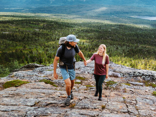 Couple friends hiking in Norway together holding hands explore mountain trails on summer vacation, travel family healthy lifestyle romantic trip active people boyfriend and girlfriend on holidays tour © EVERST