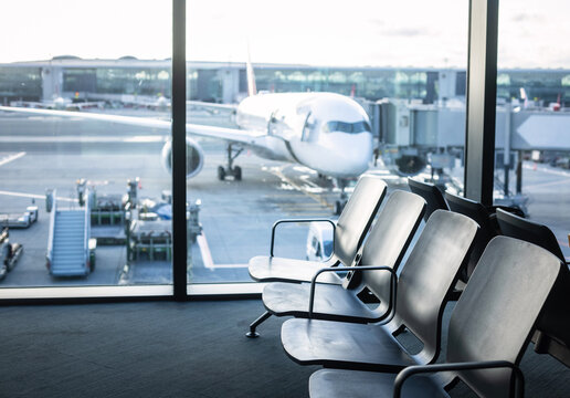 Airplane boarding area with rows of seats and large windows