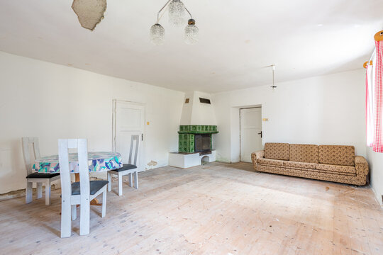 Old room with rustic tiled stove needing renovation