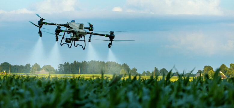 Agricultural spray drone flying over crop field for smart precision farming. Pesticide, fertilizer application. Banner with copy space