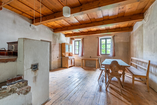 Old cottage interior featuring wooden furniture and historical stove