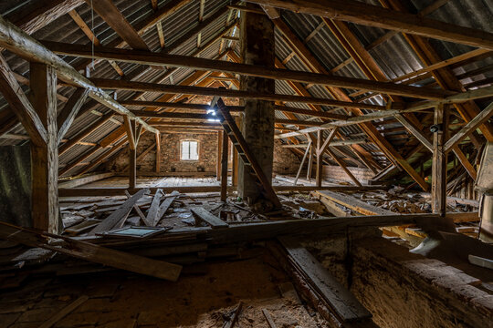 Derelict attic room showing wooden beams and roof structure