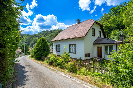 Rural house with brown roof beside winding road
