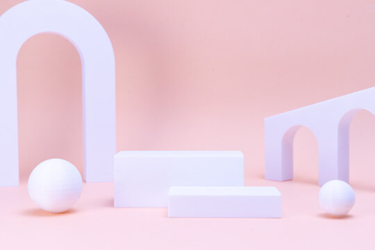 Minimalist white geometric podiums and arches on soft pink background for product display