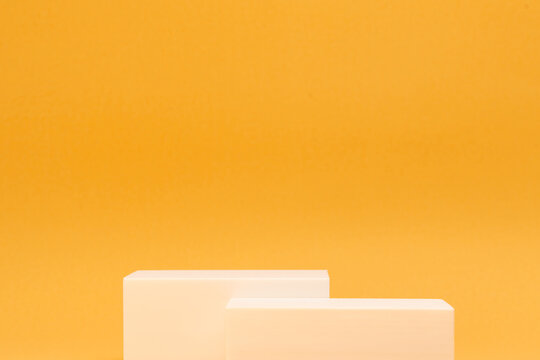 Minimalist white rectangular podiums on yellow background for product presentation