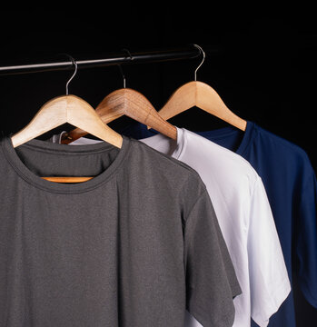 Editable mockup of a screen-printed logo on a fitted heather-gray T-shirt, featuring a close-up of the collar, displayed on a hanger in a shop window.