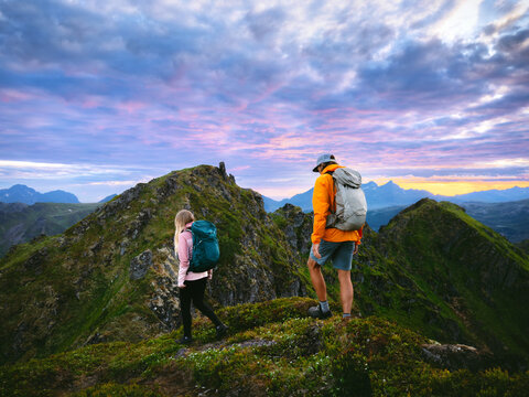 Couple hiking travel lifestyle in Norway friends climbing together explore Lofoten islands, man and woman on adventure extreme summer vacations trip leisure activity family holidays endurance trekking