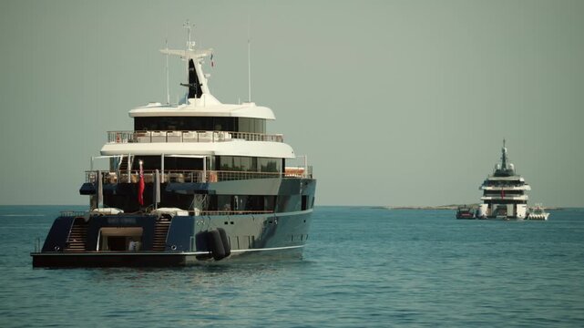 Luxurious superyacht les cinq cruising on the open sea, symbolizing wealth, private travel, and upscale summer vacations, Golfe Juan, France