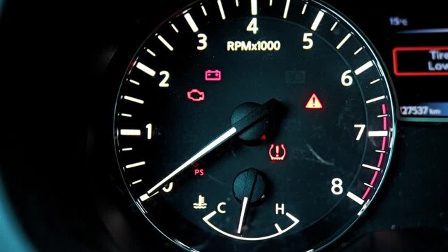 Warning lights illuminated on car dashboard tachometer gauge