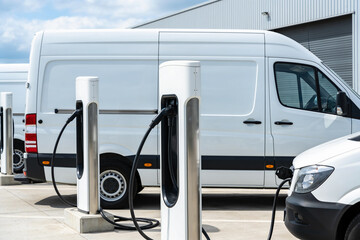 Electric vans charging at a modern charging station in an outdoor lot © Snide12