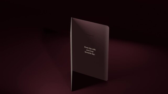 Rotating greeting card on camera shift, opening on maroon table, revealing gold hearts and message
