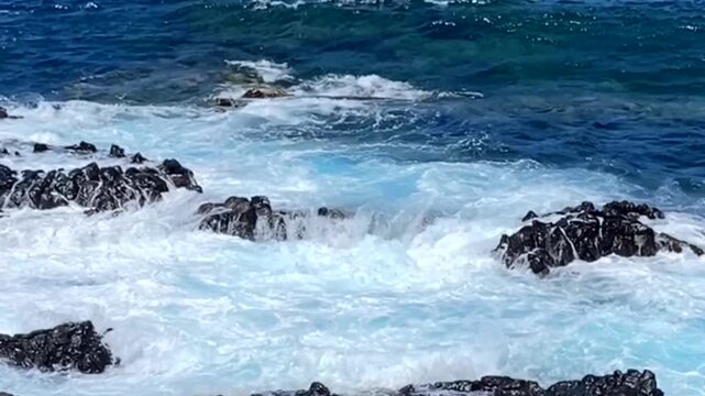 Ocean waves crashing over rocky shoreline with white foam and turquoise blue water of Los Silos, Tenerife,Canary Islands,Spain, 4K.