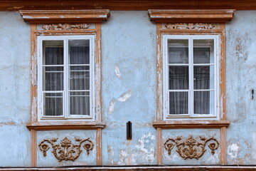 Pale-blue and ocher-orange facade with molded aprons below the windows of a two-story house on Mestni trg square west side. Skofja Loka-Slovenia-146 © rweisswald