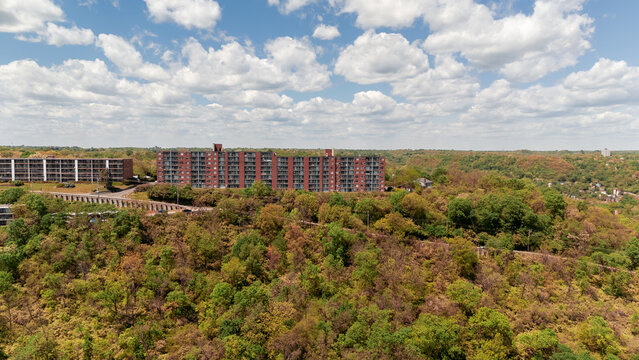 Aerial landscape view of a long bridge stretching over green forest