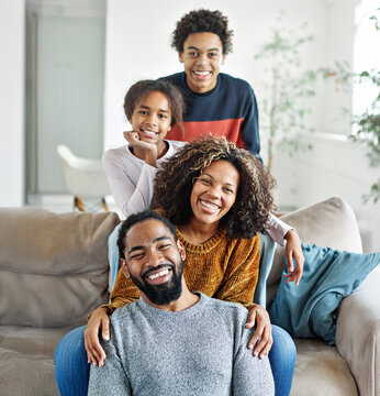 Portrait of a happy black family mother father and kids at home on couch