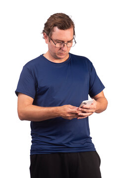 White male model wearing a short-sleeved, shiny navy blue polyamide sports shirt, looking at his cell phone.