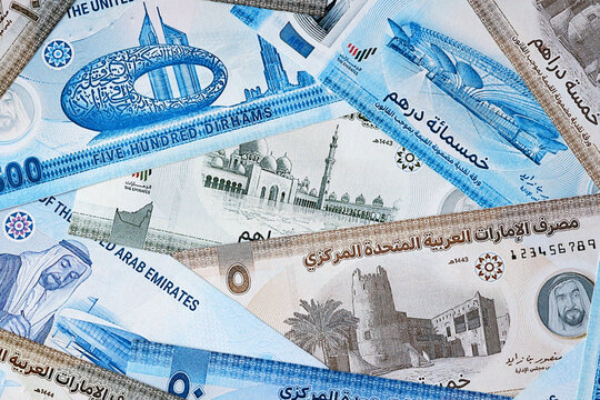 UAE dirham money bills in pile on table. United Arab Emirates AED currency cash close up